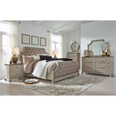 a bed room with a neatly made bed and dressers