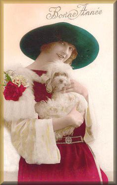 a woman holding a dog wearing a green hat and red dress with white fur on it