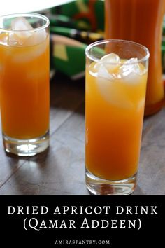 two glasses filled with drinks sitting on top of a wooden table