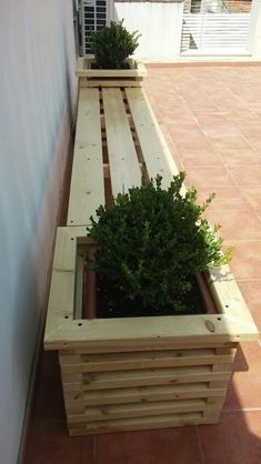 a wooden bench with two plants in it