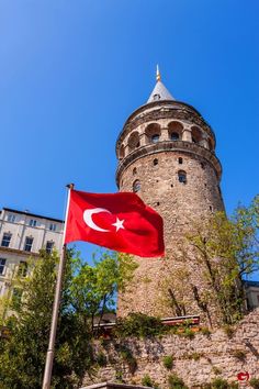 a flag flying in front of a stone tower