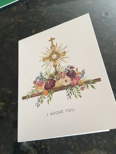 a card with the words i adore you written in gold and flowers on it