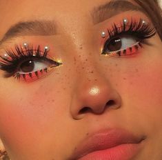 a close up of a woman's face with bright makeup and eyeliners