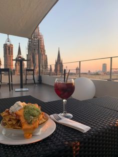 a glass of wine sitting on top of a table next to a plate of food