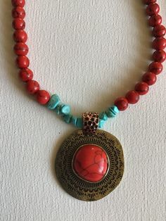 Red coral and turquoise colors necklace, cooper pendant. Red Beaded Pendant Necklace, Red Round Pendant Necklace, Red Beaded Pendant Necklace With Natural Stones, Red Necklace With Round Pendant, Handmade Red Copper Necklace, Red Copper Pendant Necklace, Red Necklace With Large Round Pendant, Red Medallion Necklace With Large Pendant, Handmade Red Medallion Necklace