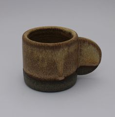 a brown and black cup sitting on top of a table