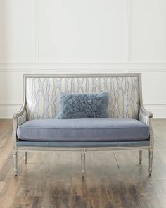 a blue and white couch sitting on top of a hard wood floor next to a wall