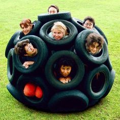 a group of people sitting on top of giant tires in the shape of a ball