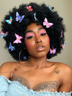 a woman with large afros and butterflies on her hair is looking at the camera