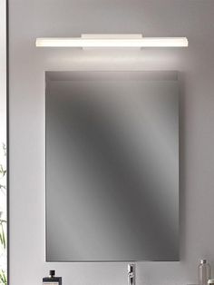 a bathroom vanity with a mirror and lights above it