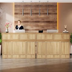 the front desk of a hotel with a woman sitting at it's reception table