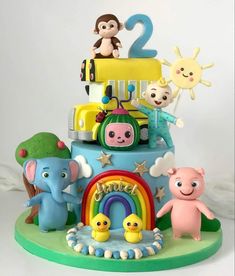 there is a cake that has animals on it and the number two in the top tier