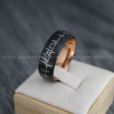 a ring that is on top of a wooden box with the words i love you