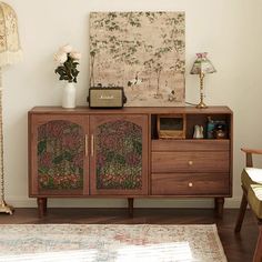 a living room with a rug, chair and cabinet