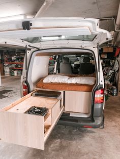 the back end of a van with an open bed and storage compartment in the trunk