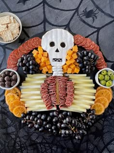 a skeleton made out of cheese, fruit and crackers