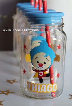 two jars with red and blue straws in them, one has a clown on it