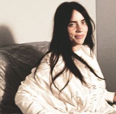 a woman with long hair sitting on a couch