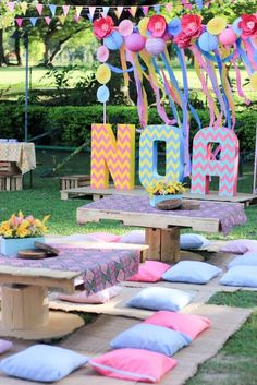 an outdoor picnic area decorated with colorful balloons and streamers for mom's day