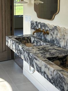 two marble sinks in a bathroom under a mirror