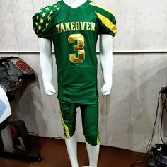 a green and yellow football uniform sitting on top of a table