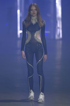 a model walks down the runway in a bodysuit