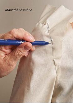 a person holding a blue pen in their left hand and writing on the other side