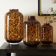 three vases sitting on top of a wooden table