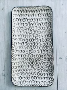 a square metal plate with circles on it