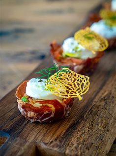 small appetizers are lined up on a wooden board