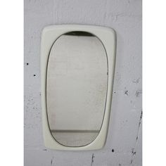 a white mirror mounted to the side of a wall