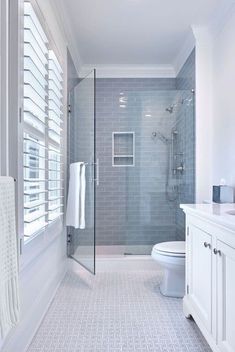 a bathroom with a toilet, sink and shower in it's center wall is shown