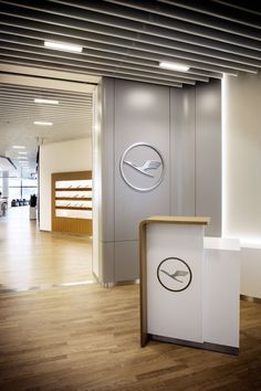 an office lobby with a clock on the wall next to a reception desk and counter