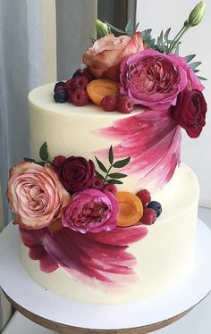 a three tiered cake with flowers painted on it