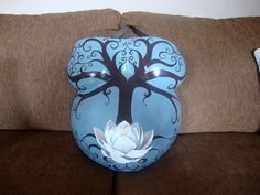 a blue vase with a tree painted on it and a white flower in the center