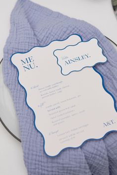 a blue and white wedding menu on a glass plate