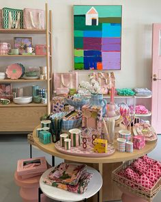 there are many items on the table in this room that is decorated with pink, green and blue colors