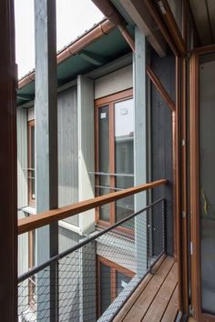 a balcony with wooden railings and glass doors