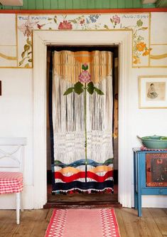 a room with a door and rugs on the floor next to an old dresser