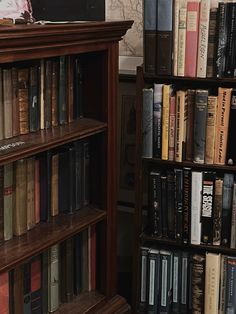 a bookshelf filled with lots of books next to a wall