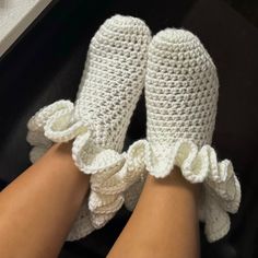 someone is wearing crocheted slippers with ruffles