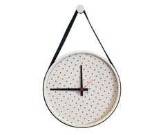 a white clock hanging from a black string