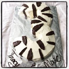 a cake with white frosting and chocolate icing on a plastic wrapper that says happy new year