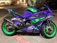 a purple and green motorcycle parked on the street