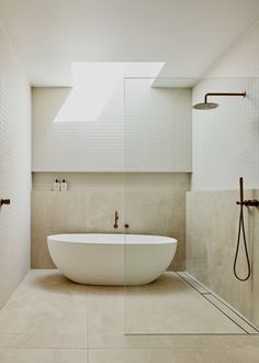 a white bath tub sitting inside of a bathroom next to a walk in shower stall