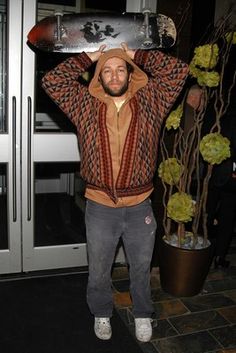 a man is holding his skateboard over his head