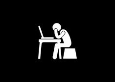 a person sitting at a desk with a laptop computer in front of him on his knees