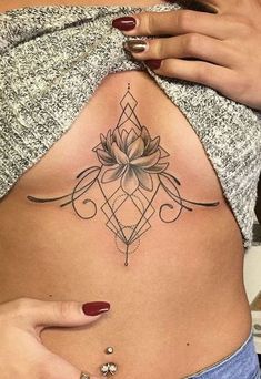 a woman's stomach with a lotus tattoo on her belly and the bottom part of her stomach