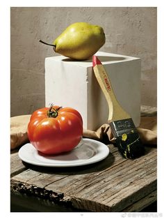 a plate with a tomato and a pear on top of it next to a brush