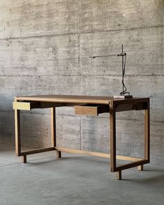 a wooden desk sitting in front of a concrete wall